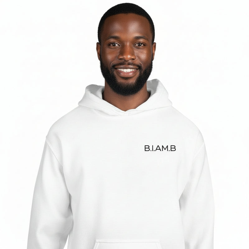 Black man wearing a white B.I.AM.B Minimal Logo Hoodie against a white background.