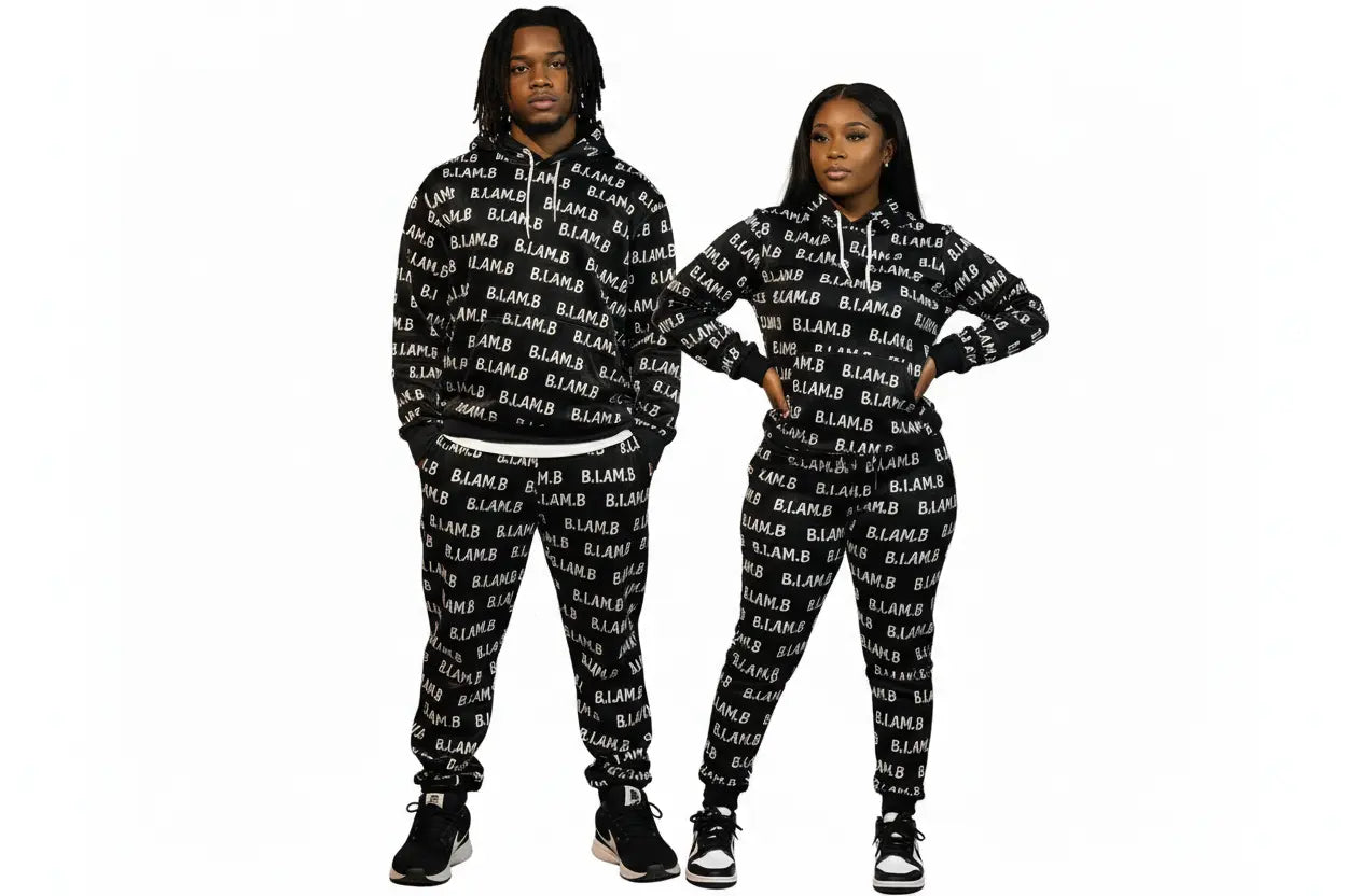 Models wearing matching black B.I.AM.B all-over print hoodie and jogger set on a white background