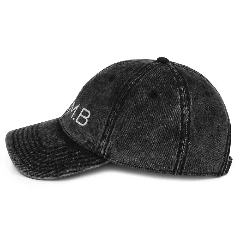 Left side view of B.I.AM.B Wear Your Power edition black dad hat showing curved brim and vintage washed fabric